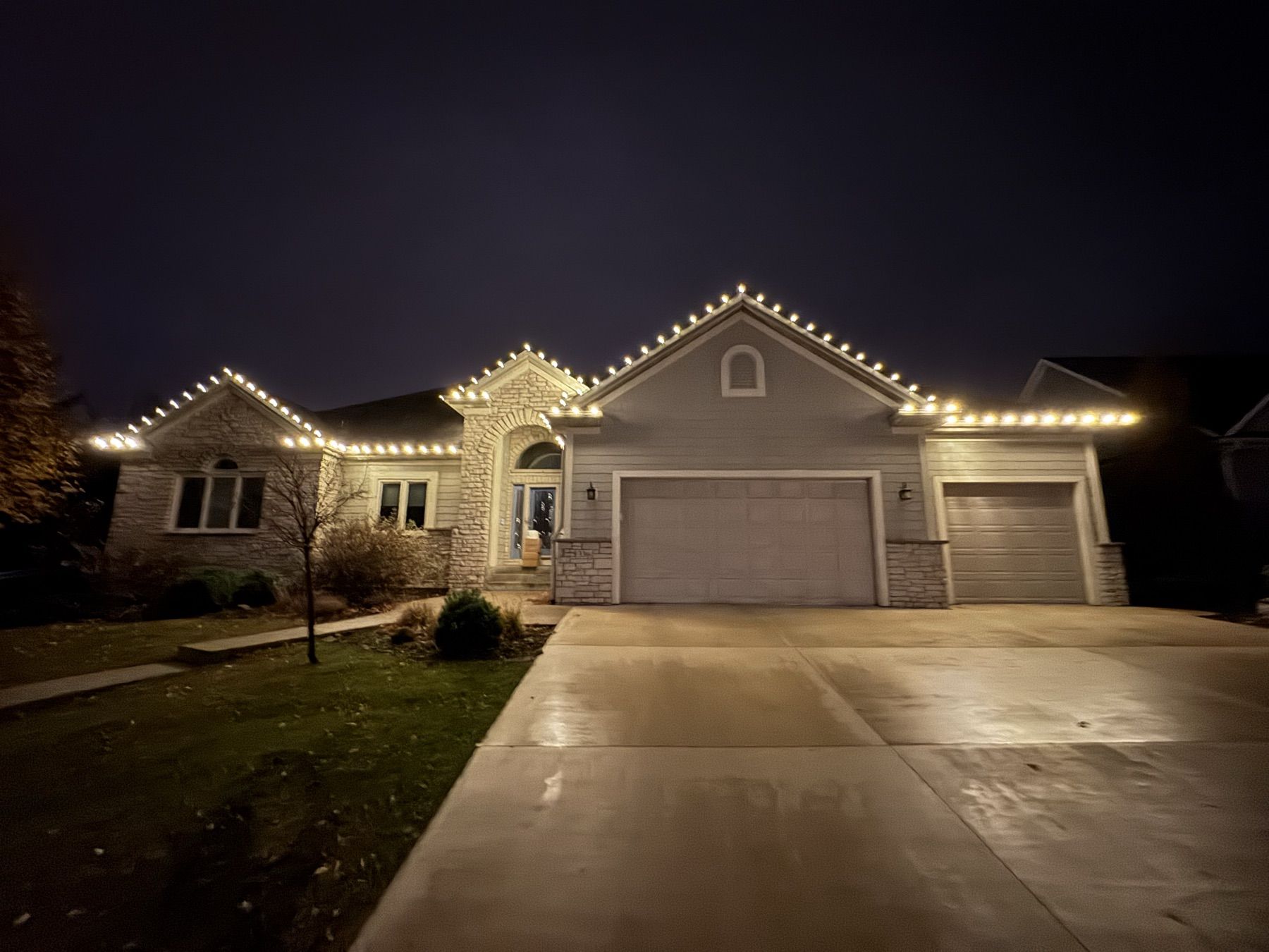 Stone-front home with lit rooflines